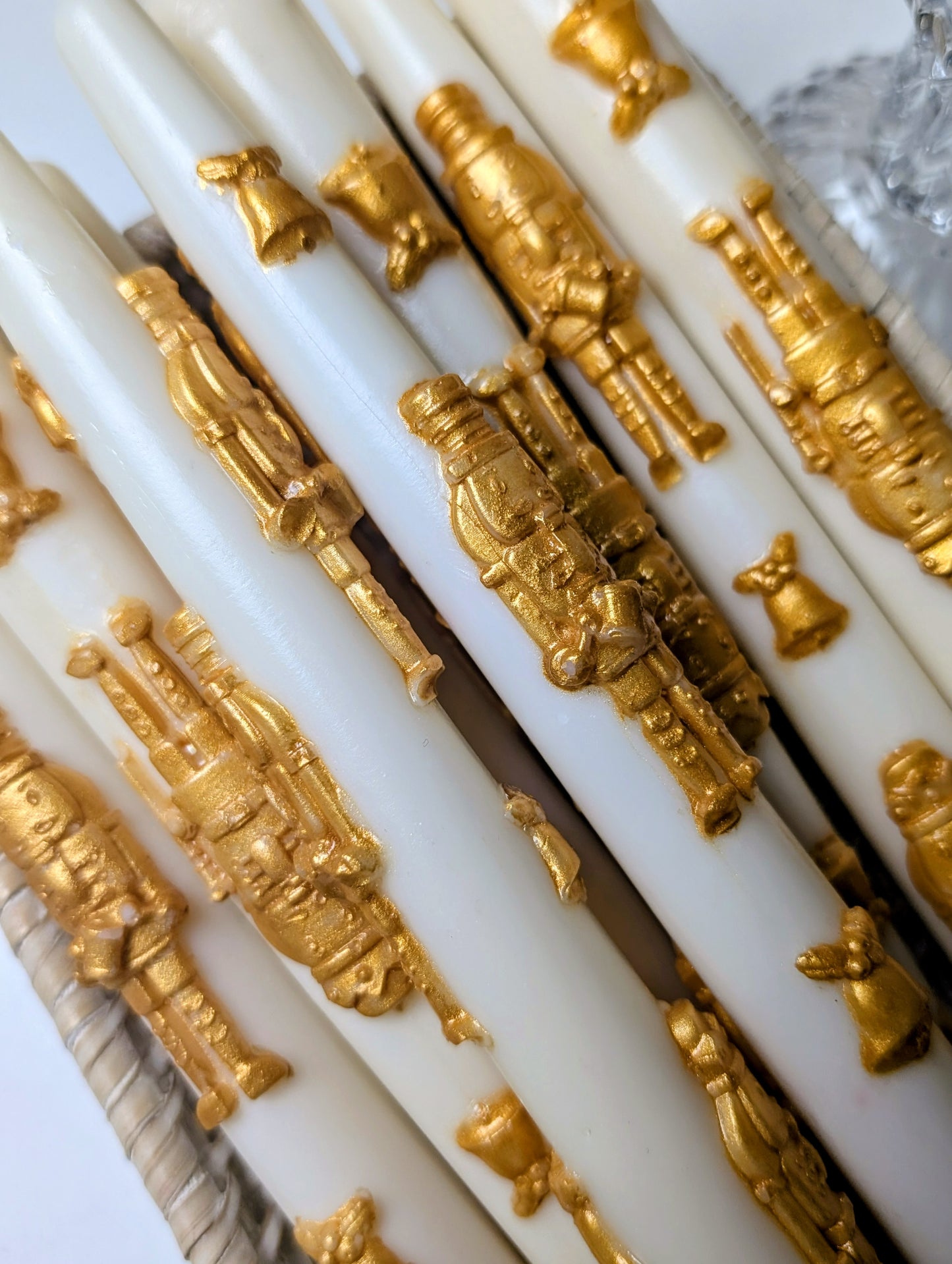 White candles with gold decorative figures on a white background